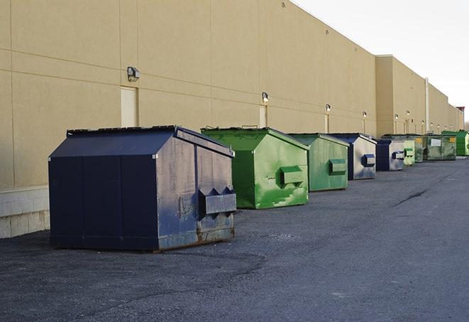 a waste management truck unloading into a construction dumpster in Frankfort